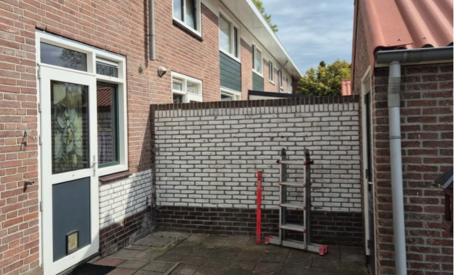 de open ruimte tussen woning en schuur waar een Douglas overkapping komt te staan