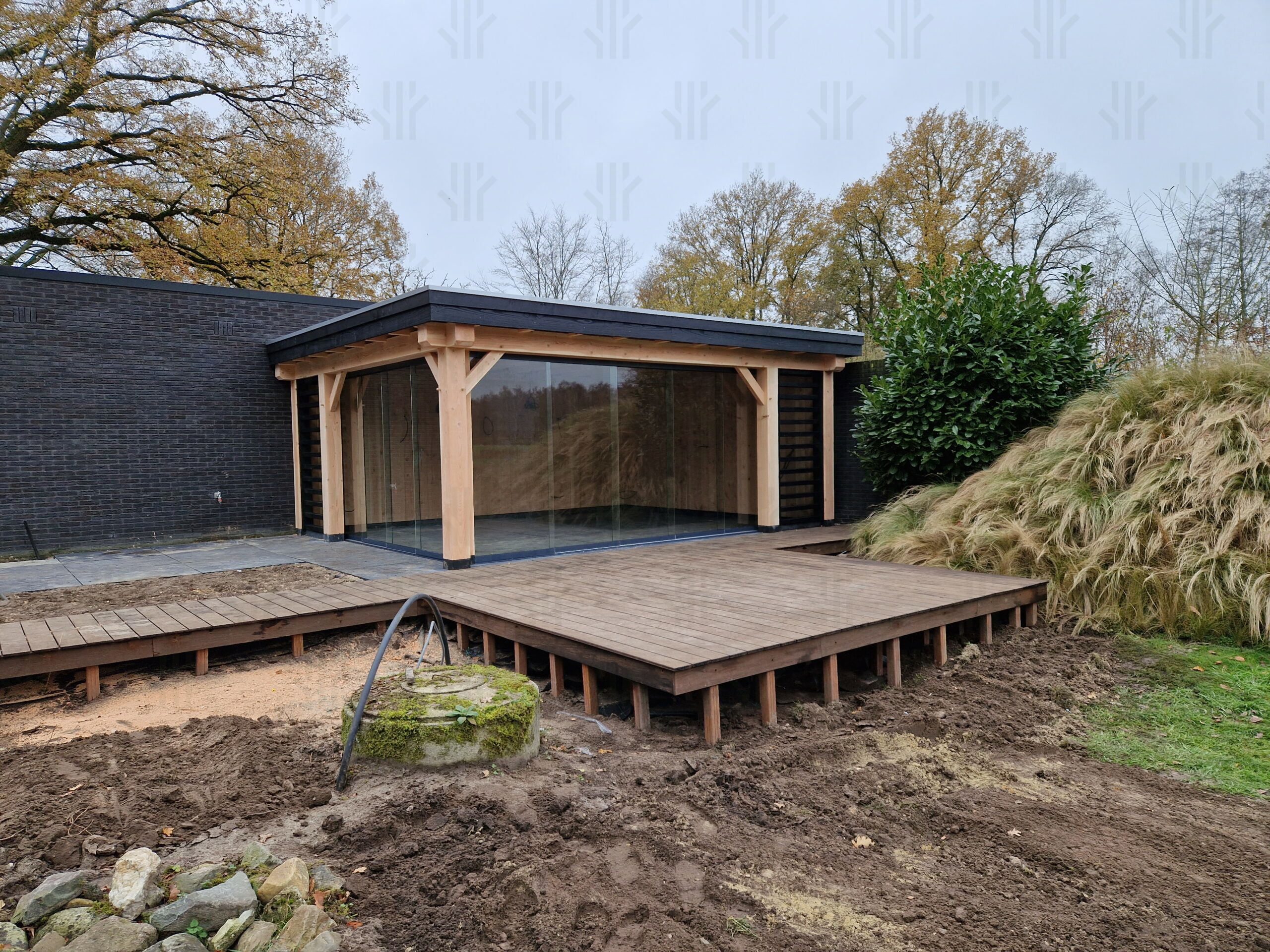 Overkapping maatwerkconstructie met plat dak uitgevoerd in een combinatie van zwart en blank Douglas hout