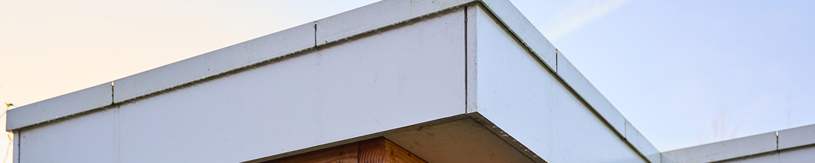 Close-up van een moderne houten overkapping met aluminium daktrim, waarbij zowel buitenhoeken als binnenhoeken zijn toegepast voor een strakke en waterdichte afwerking met EPDM.
