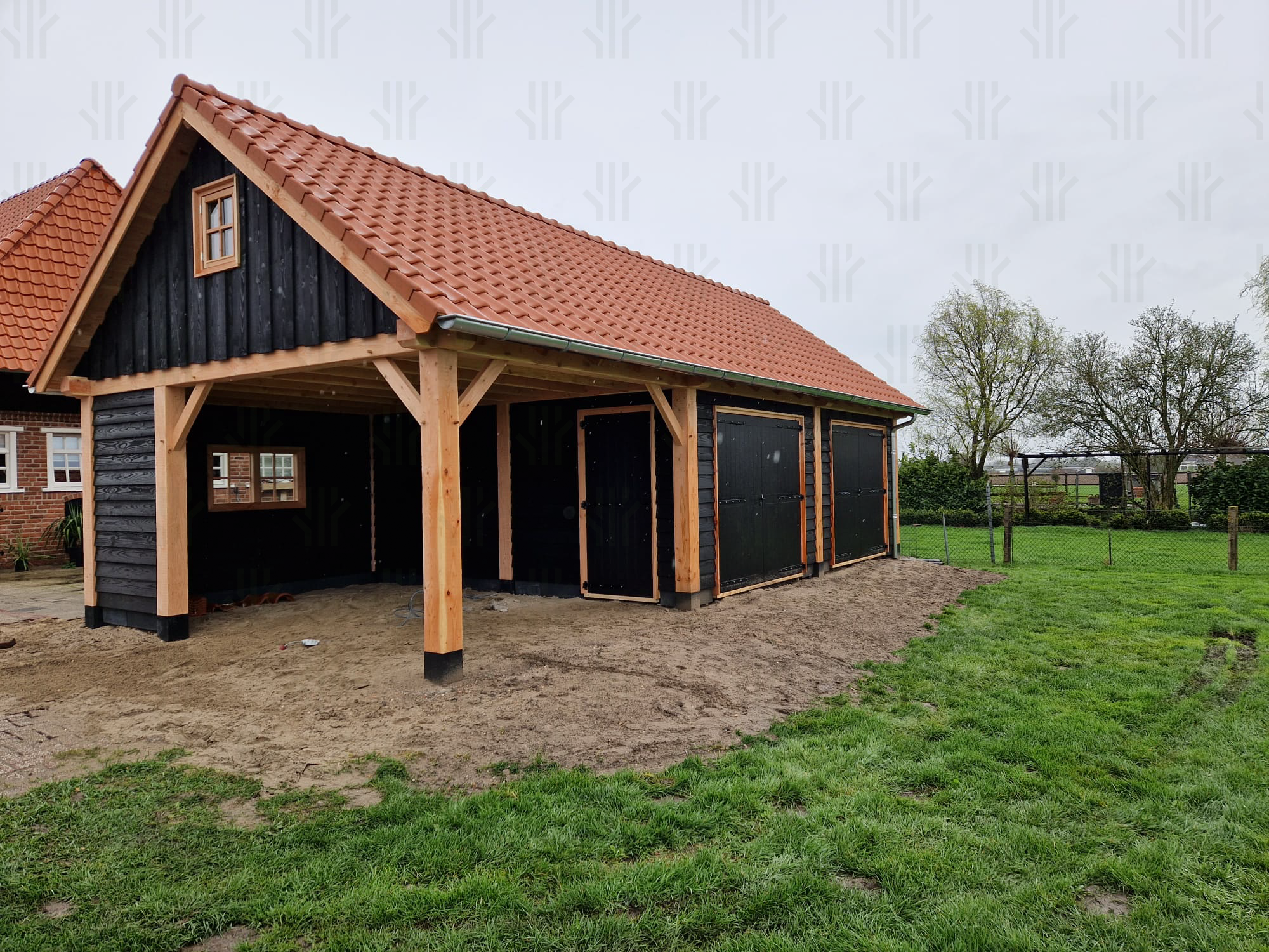Maatwerkconstructie met zadeldak uitgevoerd in een combinatie van zwart en blank Douglas hout
